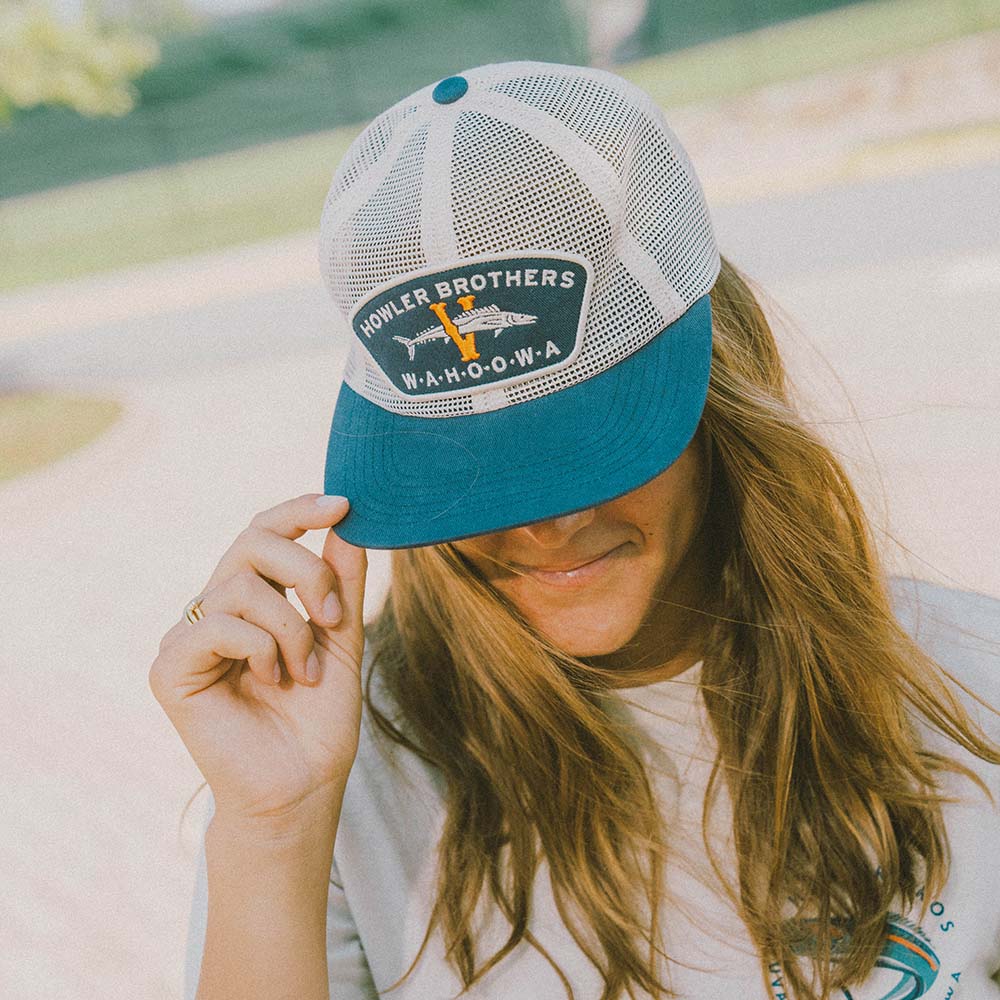 A white Howler Bros. UVA hat and tee shirt